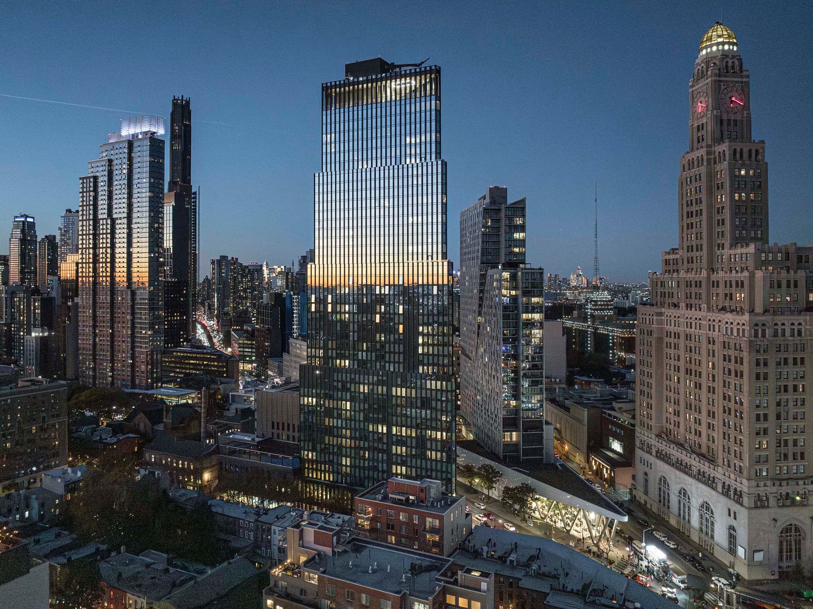 Evening skyline view of the sleek 505 State Street tower beside a historic clock tower.